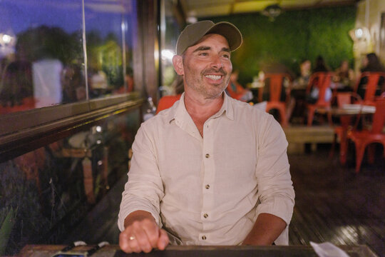 Portrait of smiling man sitting at restaurant in the evening