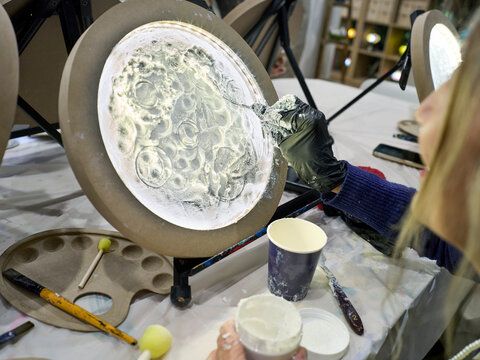 Person Creating Art Using a Moon Light at an Art Workshop