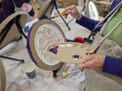 Hands Hold Paint Palette at an Art Class in a Bright Studio Space