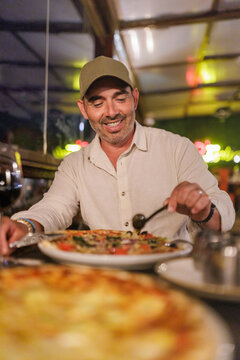 Man enjoying pizza during casual dinner at restaurant
