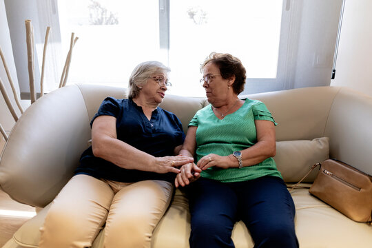 Senior women having supportive conversation on sofa