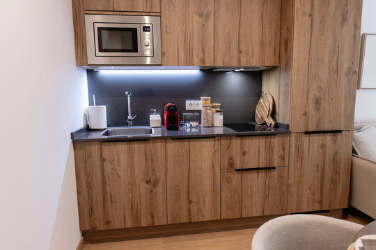 Modern apartment kitchen featuring compact design and wood cabinets