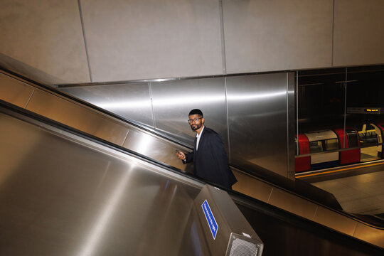 Young businessman commuting by escalator in London Underground