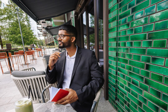 Young businessman thinking and planning career in city cafe