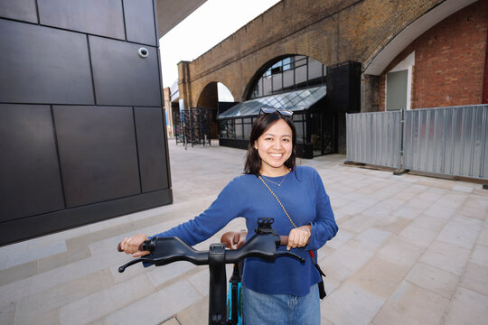 Young Filipina woman cycling in London city