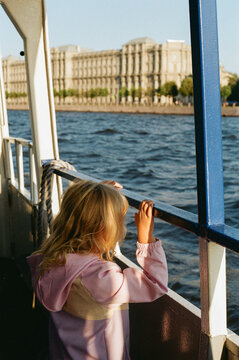 Child Looks at River View From Boat on Sunny Day