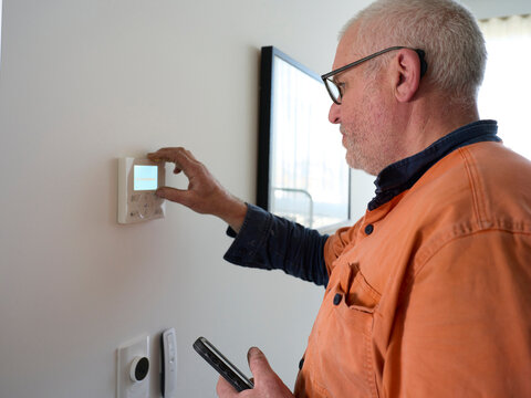 Aircon Service Man Adjusts Thermostat