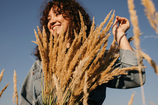 Happy woman with bouquet of dried herb