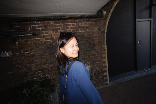 Young Filipina woman winking in urban London setting