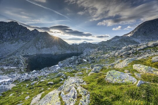 Sunrise over a mountain landscape with wo, ken rocky terrain and mountain lake, Krimml, Salzburg, Austria