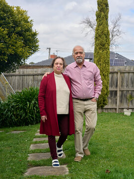 Senior Couple Stands Together in Green Garden