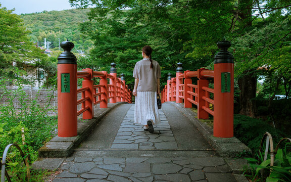 Back View of a Woman Walking on a Japanese Red Bridge