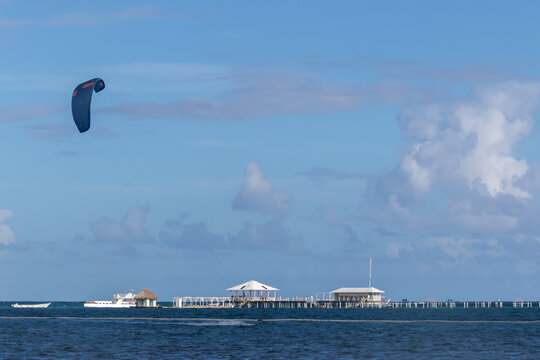 Kitesurfing sail over a long wooden pier in the ocean, Punta Cana, Dominican Republic
