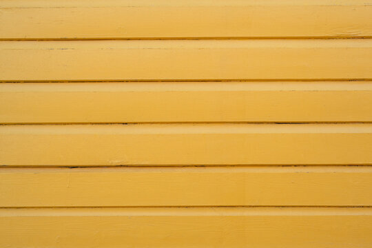 Golden yellow painted wooden boards with horizontal lines