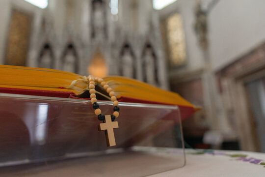 Holy mass in a church. A rosary rests on a holy book during the catholic worship ceremony.