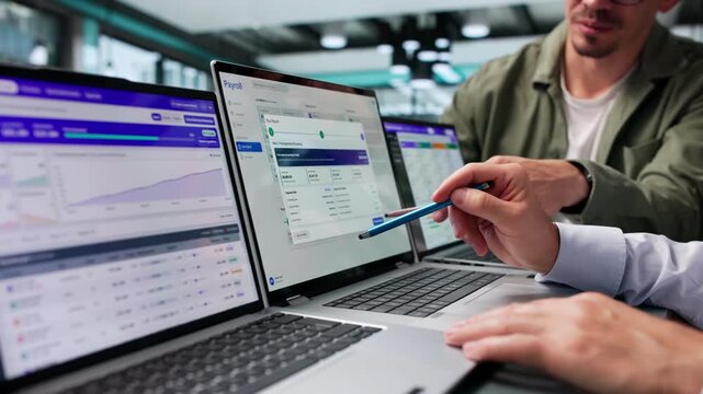 Payroll Manager Reviews Employee Salary System Using Laptop