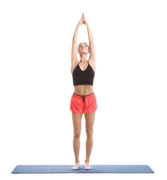 Young woman practicing yoga on fitness mat against white background
