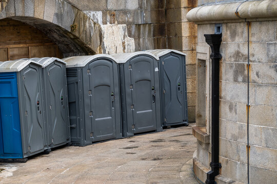 Row of Portable Toilets Beside a Stone Building
