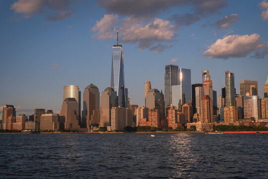 Lower Manhattan skyline lit by the setting sun, reflected on the glass of a tower, New York City, United States