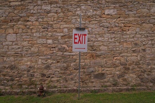 Exit sign in front of the stone perimeter wall of a historic penitentiary in Philadelphia, Pennsylvania, United States