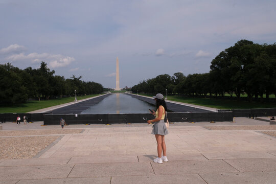 Visitor standing in front of the Lincoln Memorial Reflecting Pool and the Washington Monument in Washington, District of Columbia