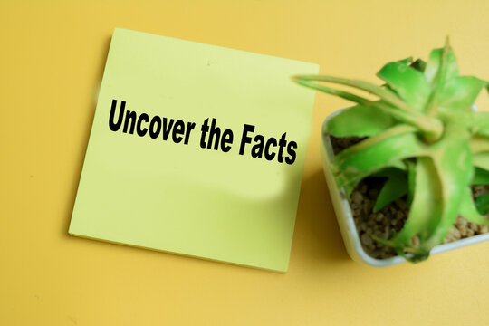 Concept of uncover the facts write on sticky notes isolated on table.