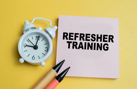 Concept of refresher training write on sticky notes isolated on table.