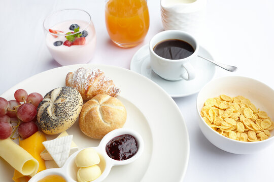 Breakfast spread with coffee, croissant, fruit, yogurt