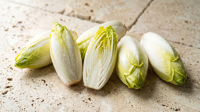 Belgian endive on stone surface with fresh crisp leaves