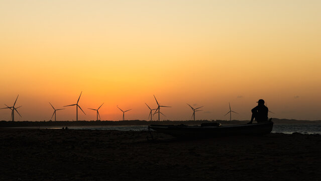 silhouettes of men practicing kite surfing in northeast of Brazil at sunset