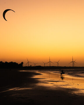 silhouettes of men practicing kite surfing in northeast of Brazil at sunset
