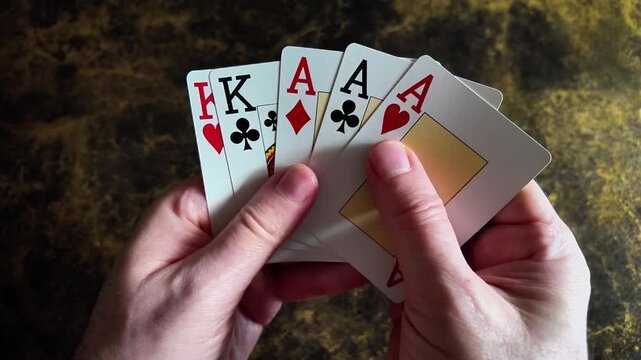Hands displaying aces and kings playing cards