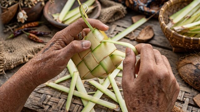 Close Up Of Elderly Grandmother Hands Weaving Ketupat Traditional Indonesian Rice Cake From Young Coconut Leaves