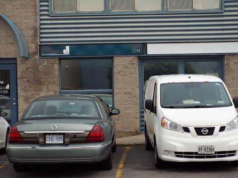 Gloucester, Ontario, Canada &ndash; July 29, 2026: The "Urban Community Condo Managers" storefront sign is displayed above a commercial building entrance with parked vehicles in front at 1010 Polytek St Uni