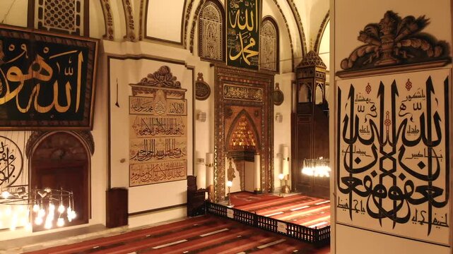 Ornate mihrab and Islamic decoration glow inside Bursa Ulu Cami at night in Turkiye.