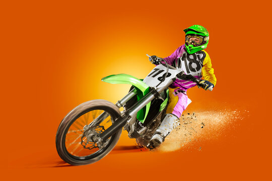 Motocross. Sports concept. Professional athlete against an orange background. Athlete in action. Sport.