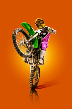 Motocross. Sports concept. Professional athlete against an orange background. Athlete in action. Sport.