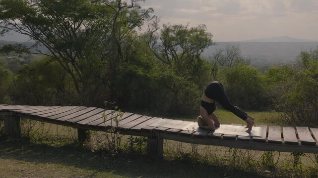 Woman flows from headstand into a poised scorpion pose above a misty valley