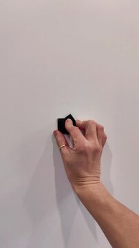 Female hand closes the peephole cover on a white entrance door, home security and privacy, everyday household action, vertical video.