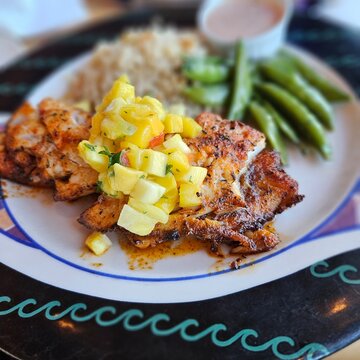 Grilled fish topped with fresh pineapple salsa served with rice and green beans