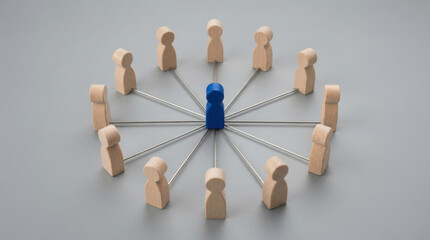 Obraz premium Centralized blue wooden pawn connected to surrounding neutral figures symbolizing leadership and organizational communication.