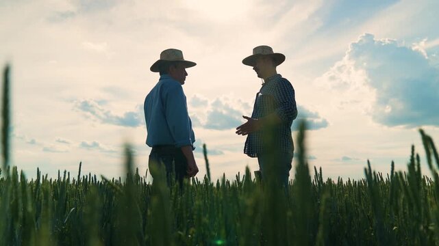 Farmers shaking hands in wheat field, Agriculture partnership on the field, Friendly handshake between farm workers, Rural businessmen agreement, Two men meeting on farm, Wheat field handshake at