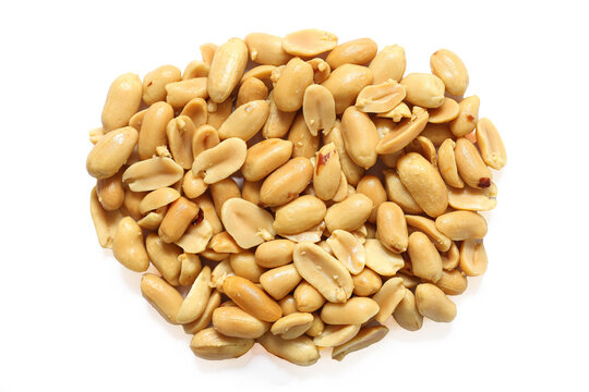 Roasted peanuts isolated on white. Shelled peanut kernels pile. Golden savory snack food background. Salted nuts close up. Protein rich legume assortment. Crunchy edible seeds. Natural food detail.