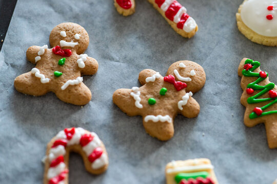 Festive gingerbread cookies with colorful icing on a baking sheet.