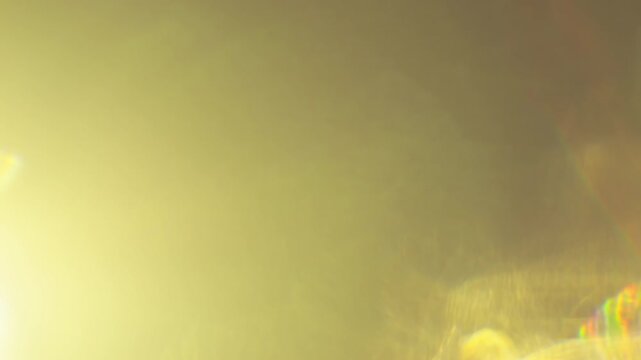 Golden refracted rays and a soft circular glow spread across a dark olive frame, creating a prismatic abstract light texture for cinematic overlays, transitions, backgrounds and compositing.