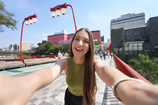 Visiting Sao Paulo, Brazil. Happy young woman takes selfie in Liberdade neighborhood of Sao Paulo, Brazil.