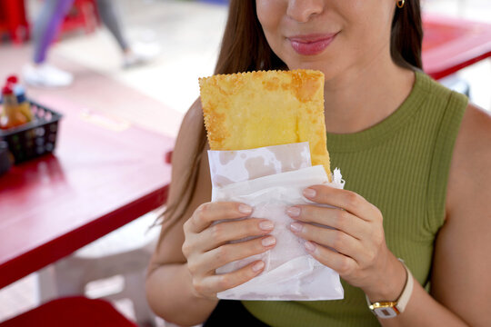 Unidentified girl holding Pastel de feira a typical Brazilian stuffed fried pastry in street market