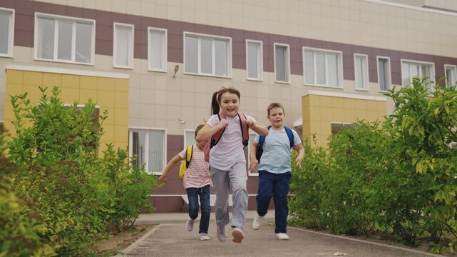 School children sprinting, outdoor plaza, spacious campus, teamwork building, knowledge quest, first lesson excitement, eager minds, diverse students, vibrant education, inclusive environment.