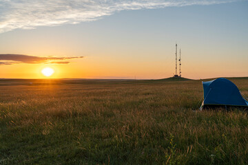 Tent Camping on Prairie Grassland at Sunset with Radio Towers © Brian