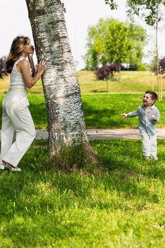 Mother and son playing hide and seek in park
